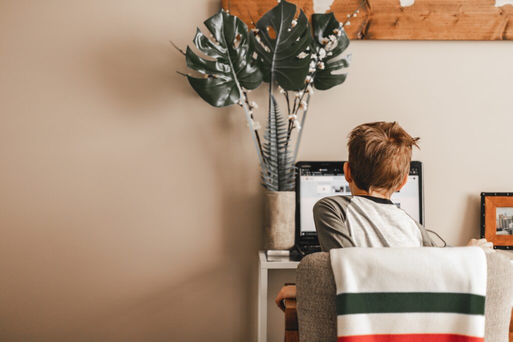 A child experiencing virtual learning for kids while sitting at a computer at home