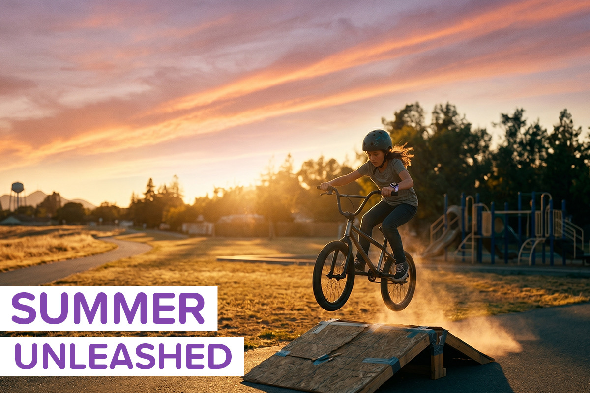 An image of a tween girl riding her bike off a ramp in a park