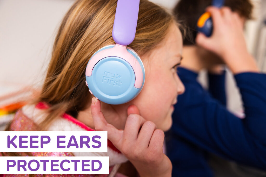 Two tweens wearing safe headphones for kids in different colors